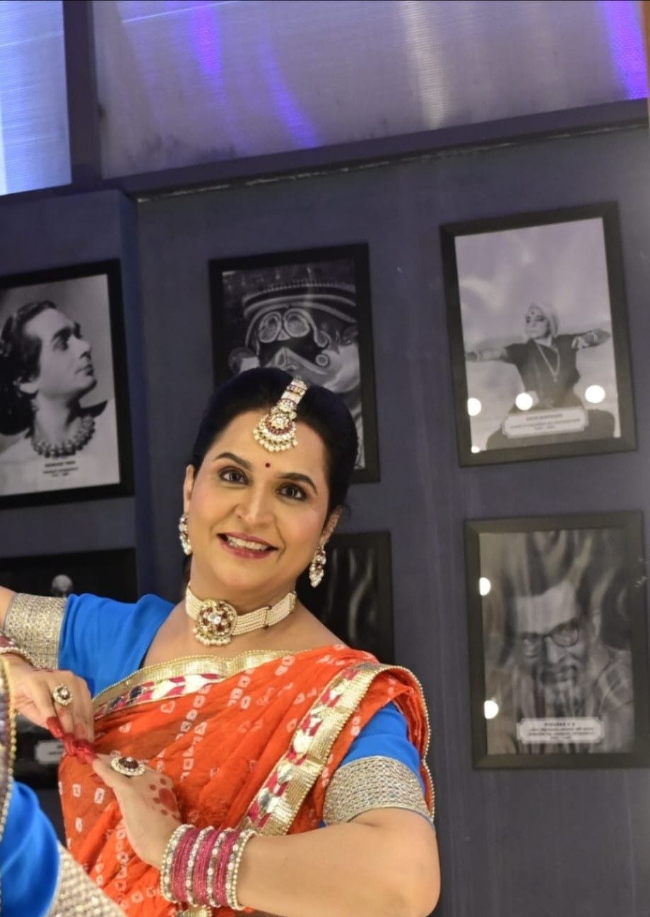 Shalu, founder of NrityaShrm, beside photographs of her gurus