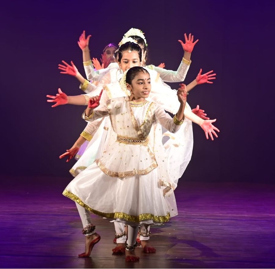 Kathak students forming the many arms of the Goddess